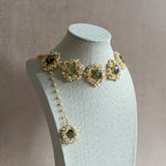 Transform any outfit with the Grace Crystal Choker Set! Adorned with natural prehnite gemstones and sparkling cubic zirconia, this set is sure to add a touch of elegance and glamour. The adjustable chain ensures the perfect fit, and it comes complete with matching earrings and tikka. Elevate your style with this stunning set!
