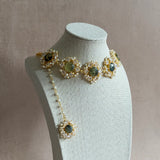 Transform any outfit with the Grace Crystal Choker Set! Adorned with natural prehnite gemstones and sparkling cubic zirconia, this set is sure to add a touch of elegance and glamour. The adjustable chain ensures the perfect fit, and it comes complete with matching earrings and tikka. Elevate your style with this stunning set!