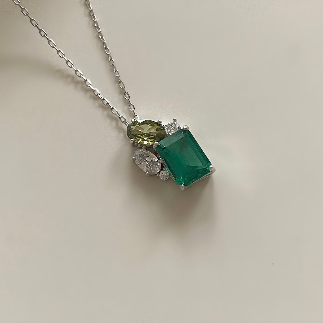This sterling silver necklace will add a subtle sparkle to any night out. The delicate faceted crystal zirconia stones provide a beautiful and eye-catching contrast of hues of green and olive, pair with green crystal studs for a unique and unforgettable look.  Necklace drop 23cm