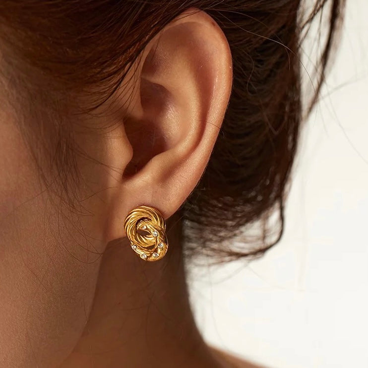 Twist Crystal Studs are the perfect way to add subtle sophistication to any look. Crafted from faceted crystals, these studs shimmer and sparkle in the light, catching eyes with their subtle yet striking style. The classic, minimalist design is perfect for any wardrobe.  18k gold plated  Earring drop 3.5cm