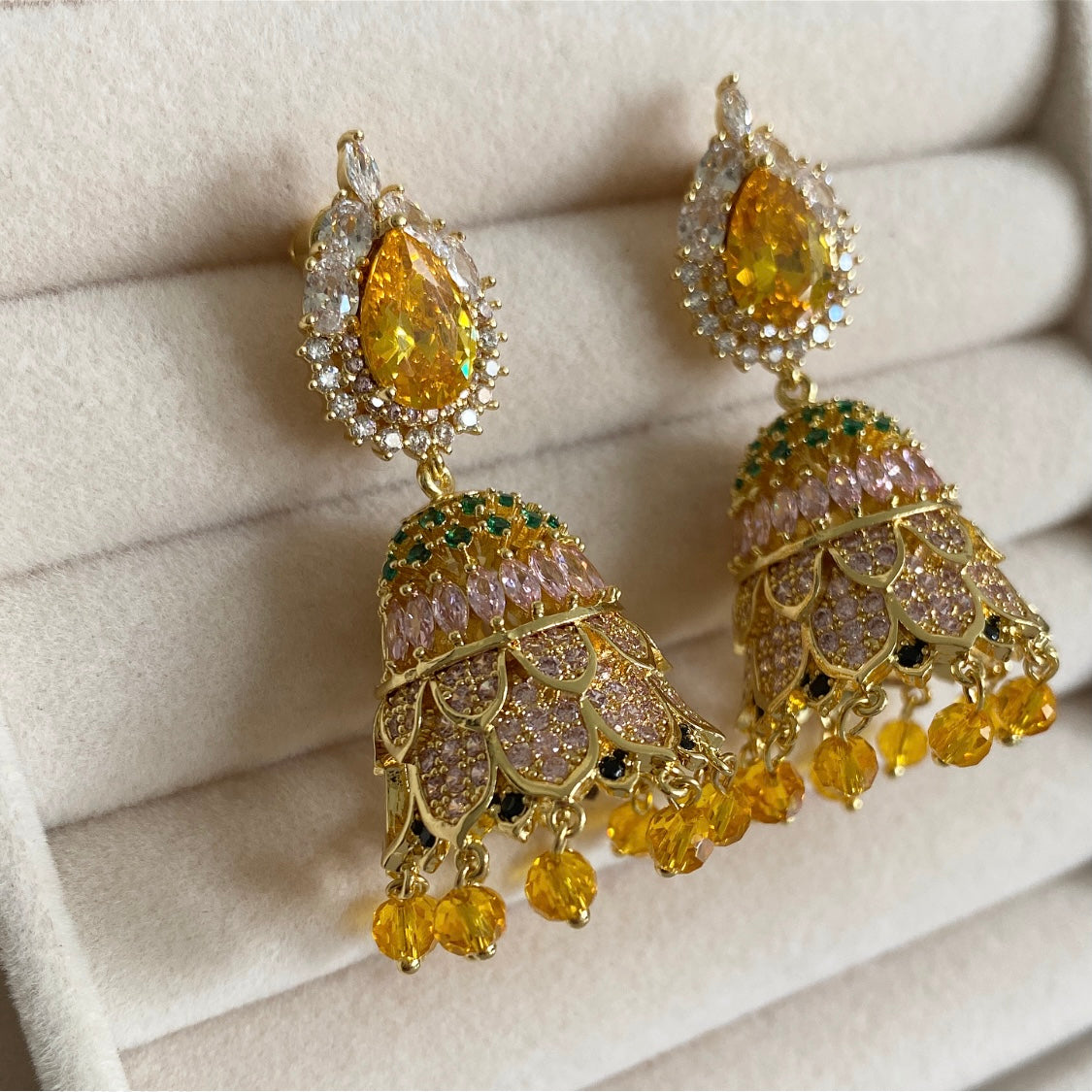 Aaliya Jhumki Earrings offer a timeless, classic look with a modern twist. Intricately crafted jhumki earrings feature shimmering CZ crystals, which reflect light beautifully and make a statement wherever they are worn. The combination of traditional style with a contemporary look make these earrings a perfect choice for any occasion.